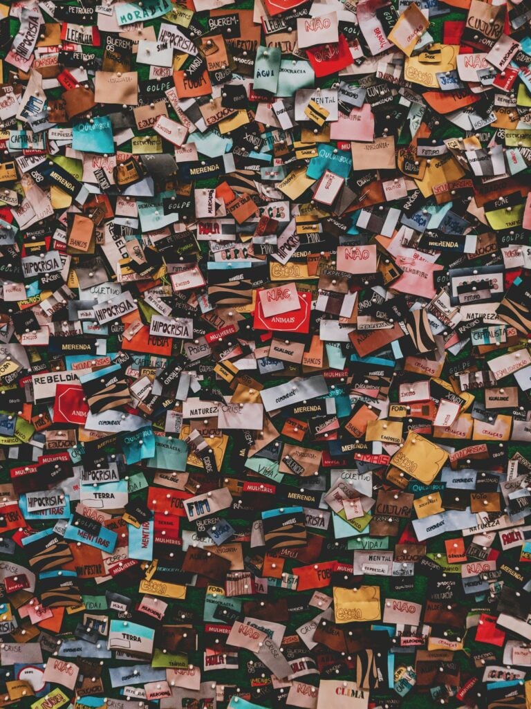A chaotic collage of colorful stickers on a wall, offering a vibrant and textured visual pattern.